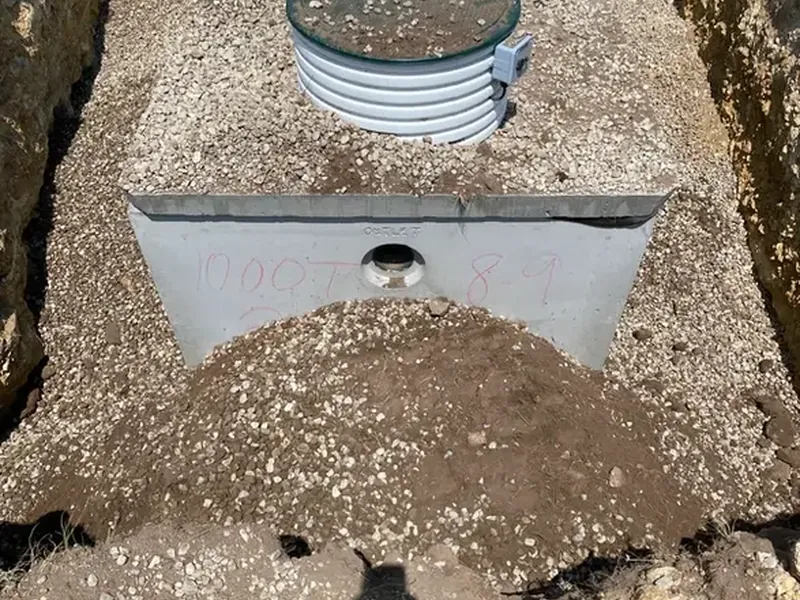 Photo: a septic riser lid set in gravel after backfill
