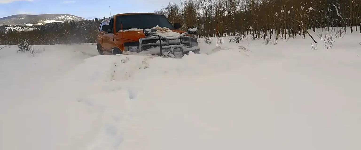 Photo: a plow pushing snow across an open lot in Park County after a storm